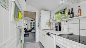 Una cucina moderna con mobili bianchi, una macchina da caffè e un bollitore.