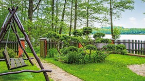Un jardín con un columpio, un sendero de ladrillos y una valla de madera.