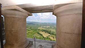 Vista a través de columnas de piedra con un paisaje rural al fondo.