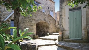 Un edificio de piedra con una puerta verde, un arco de piedra y escalones que conducen a un nivel superior.