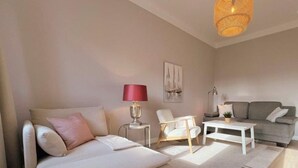 A modern living room with a sofa, armchair, and coffee table. - (129/3) 2-room apartment - apartment house Plückhahn (Kühlungsborn)
