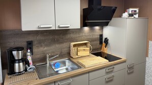 Une cuisine moderne dotée d’un évier en acier inoxydable, d’une machine à café et d’un bloc à couteaux.