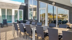 An outdoor patio with a table and chairs, large windows, and a view of the surrounding area. - Awesome home in Ebeltoft with sauna (Ebeltoft)