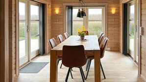 Un interior de madera con una mesa de comedor, sillas y una planta en maceta.
