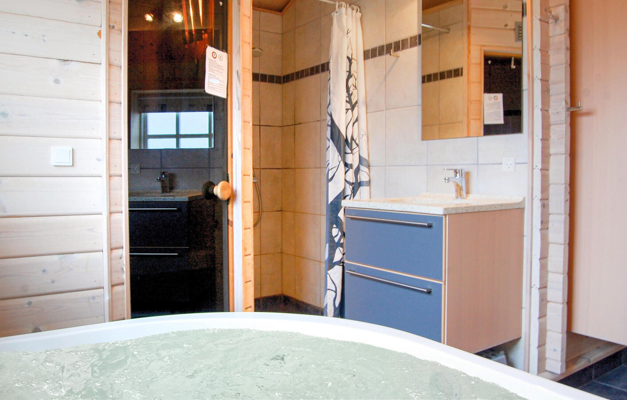 A bathroom with a bathtub, a sink, and a mirror.