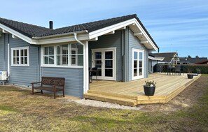 A house with a covered porch, a bench, and a potted plant. - Amazing home in Rudkøbing with sauna (Rudkøbing)