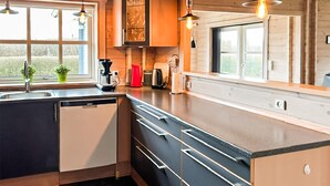 Una cocina moderna con lavavajillas, cafetera y tostadora.