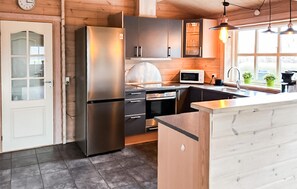 A modern kitchen with a stainless steel refrigerator, a microwave, and a sink. - Amazing home in Rudkøbing with sauna (Rudkøbing)