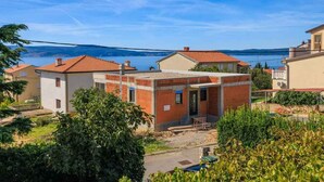 Un quartier résidentiel avec des maisons, un ciel dégagé et une étendue d’eau en arrière-plan.