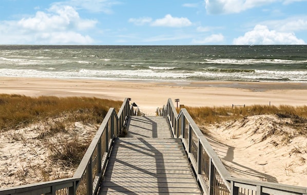 A wooden boardwalk leading to a beach with a view of the ocean. - Gorgeous apartment in Darlowo with WiFi (Darlowo)