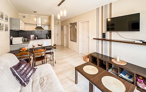 A compact living space with a kitchenette, a dining area, and a TV mounted on the wall. - Gorgeous apartment in Darlowo with WiFi (Darlowo)