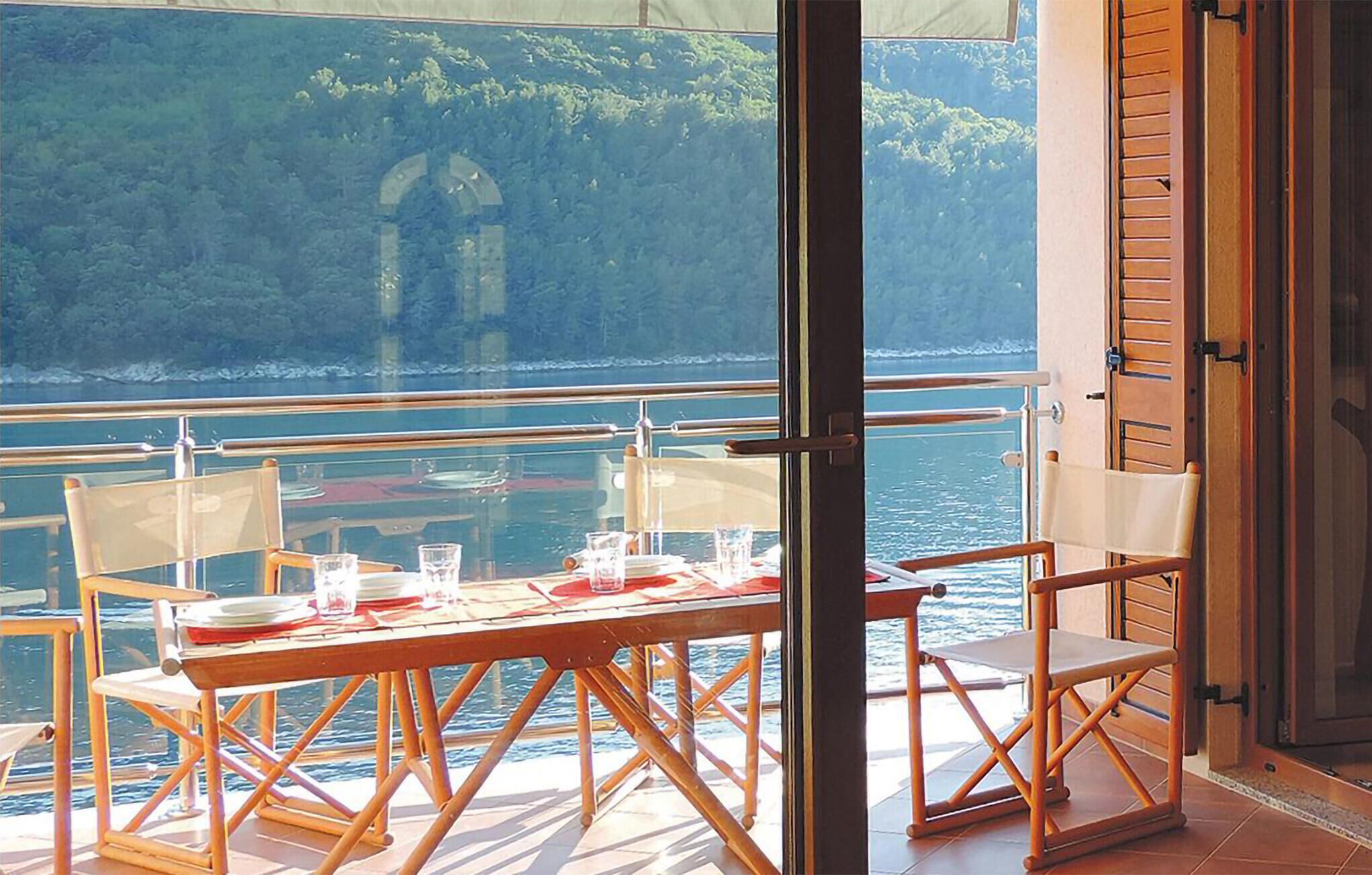 Ein Tisch für zwei Personen mit Blick auf das Meer und eine gebirgige Landschaft.