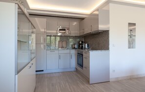 A modern kitchen with built-in appliances, a granite countertop, and a minimalist design.