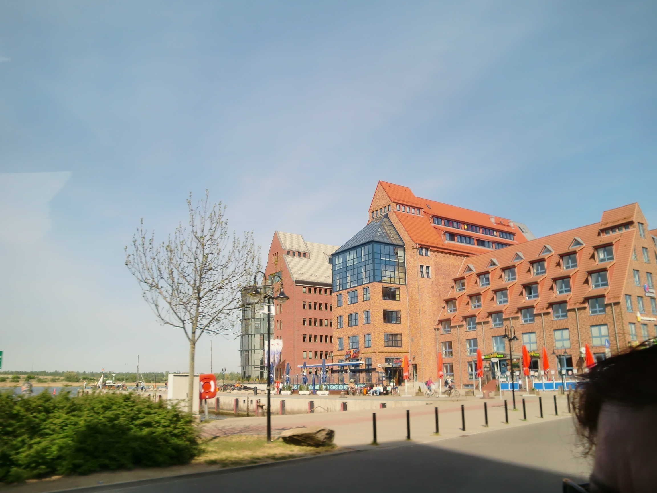 Ein großes Backsteingebäude mit mehreren Stockwerken und einer markanten Glasfassade.