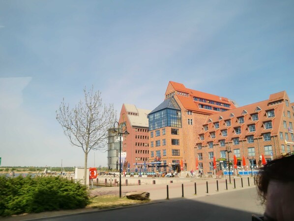 A large brick building with multiple floors and a prominent glass section.