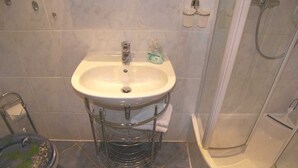 A bathroom with a sink, a toilet, and a shower. - Apartment 02 - Apartments Oechsner (Heringsdorf)