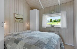 A bedroom with a bed, a window with curtains, a wall-mounted lamp, and a painting. - Beautiful home in Nordborg with WiFi (Nordborg)