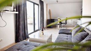 A modern living room with a sofa, a coffee table, and a TV.