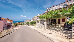 A coastal street with stone buildings, a clear sky, and a view of the sea. - Beautiful apartment in Crikvenica (Crikvenica)