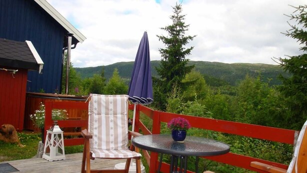 Eine Terrasse mit einem Stuhl, einem kleinen Tisch und einer Laterne.