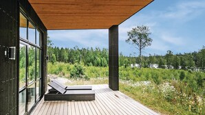 A wooden deck with a glass wall overlooking a forested area. - Beautiful home in Holmsjö with WiFi (Holmsjö)