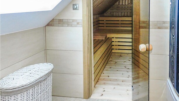 Una estrecha escalera de madera que lleva a un altillo con tragaluz.
