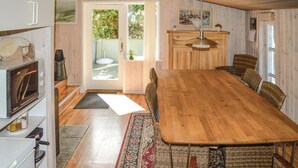 A spacious kitchen with a large wooden table, wicker chairs, and a view through the glass door to the outside. - 3 bedroom beautiful home in Sæby (Sæby)