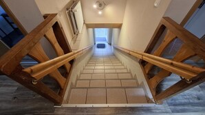 Eine Holztreppe mit Handlauf, die zu einer oberen Etage führt.