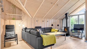 A cozy living room with a sofa, a chair, a table, and a fireplace. - Awesome home in Oksbøl with sauna (Oksbøl)