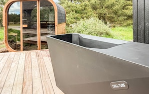 A modern outdoor kitchen area with a built-in grill and a wooden deck.