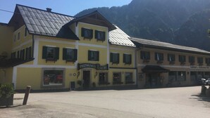 Ein gelbes Gebäude mit einem Schild, auf dem 'GASTHOF a. FLEISCHHAUERER' steht.