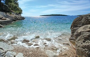 A pebble beach with clear water and rocky shores. - Lovely home in Prizba (Prizba)