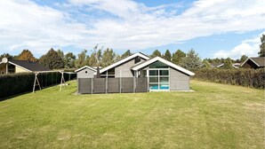 Una propiedad residencial con patio trasero cercado, piscina y un ventanal grande.