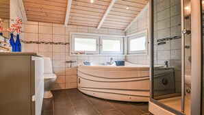 Ein modernes Badezimmer mit einer freistehenden Badewanne, einer Duschkabine und einer Toilette.