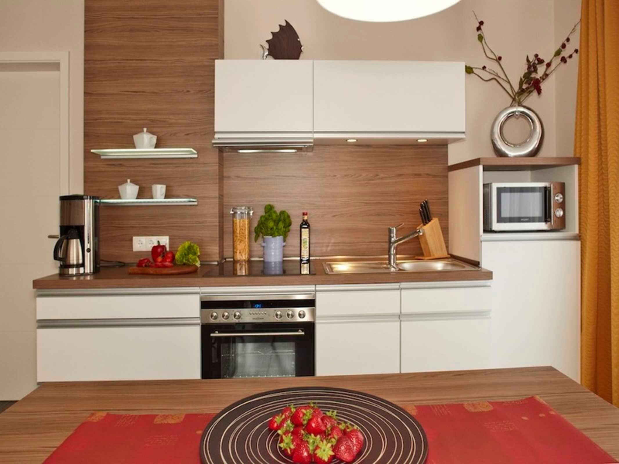 A modern kitchen with a built-in oven, a microwave, and a sink.