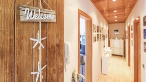 Una porta di legno con una scritta 'Welcome' e decorazioni a stella marina.