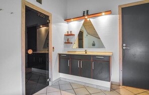 Ein Badezimmer mit einem schwarzen Schrank, einem Spiegel und einem Waschbecken.