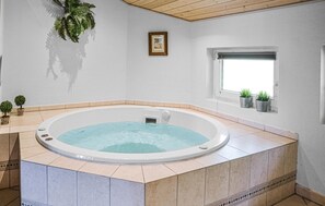 A hot tub in a room with a window, tiled floor, and a small plant on the windowsill. - Cozy home in Blåvand with sauna (Blåvand)