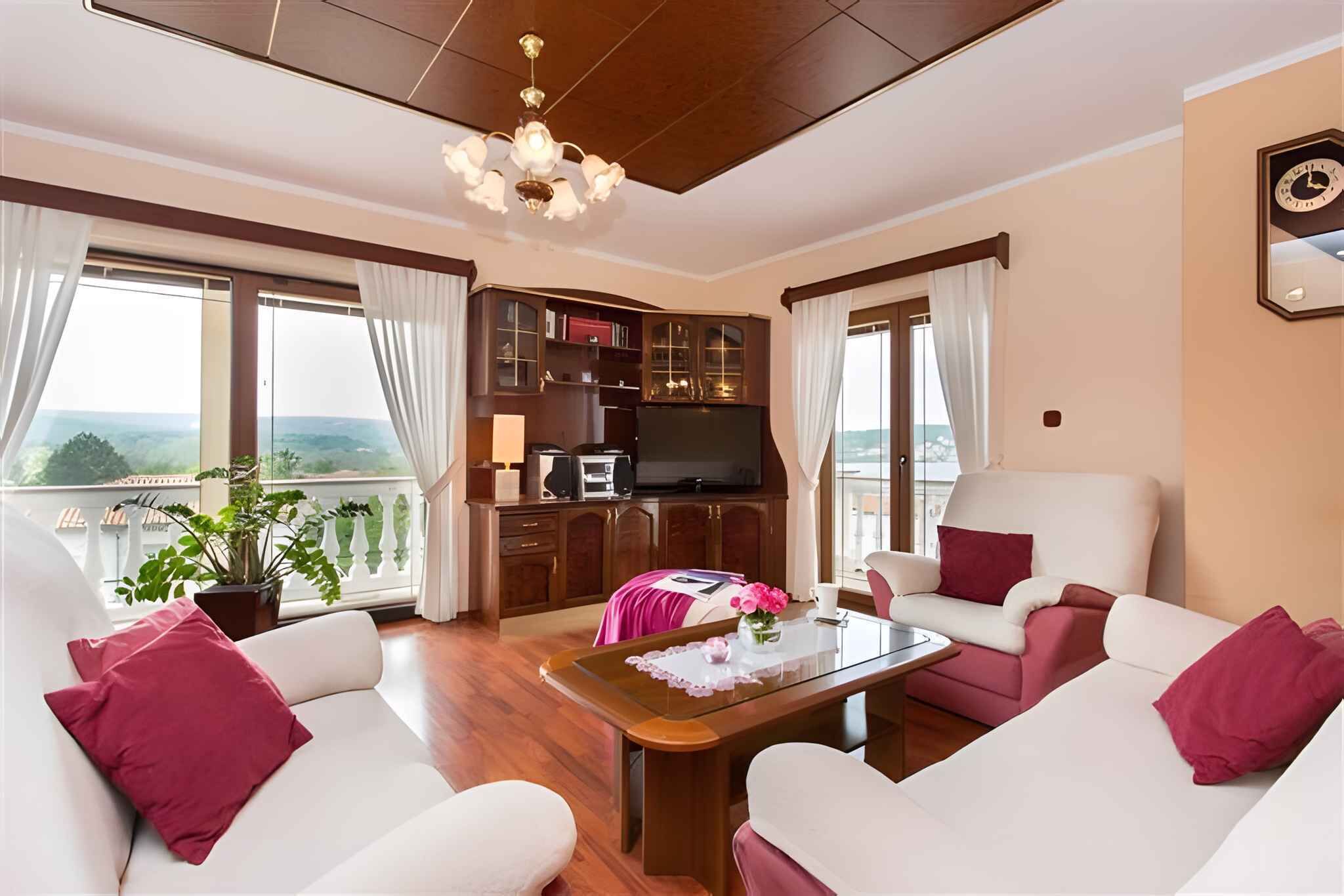 A living room with a sofa set, a coffee table, a TV, and a bookshelf.