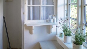 A room with a white window, a shelf with two bottles, and two potted plants on the windowsill. - 3 bedroom awesome home in Mårdaklev (Mårdaklev)
