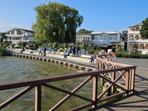 A riverside walkway with benches, a wooden bridge, and buildings in the background. - Apartment 1 - NEW! Rental Binz (Binz)