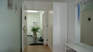 A hallway with a potted plant, a door, and a mirror. - Apartment 1 - NEW! Rental Binz (Binz)