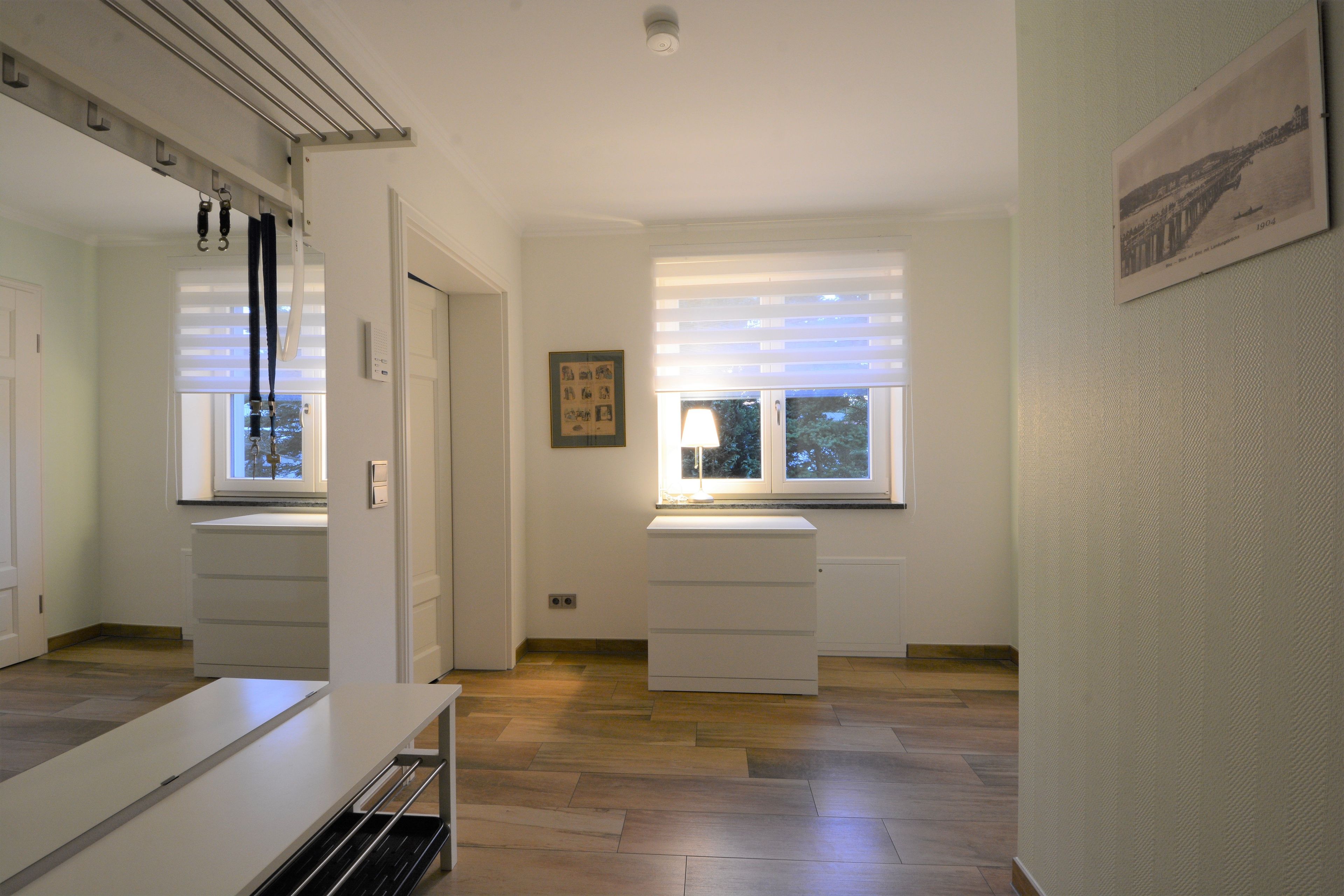 Ein Zimmer mit einem großen Fenster, einem weißen Schrank und einer Tür.