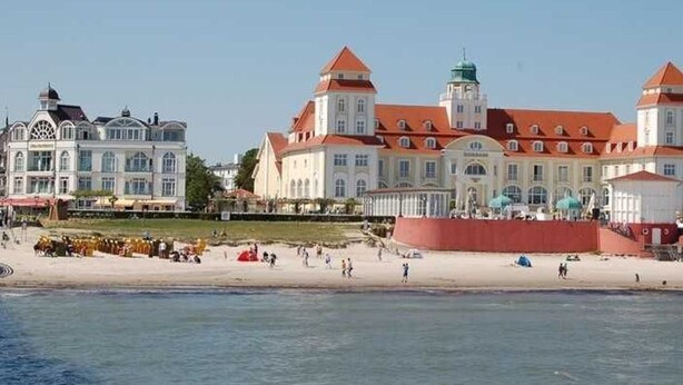 A waterfront hotel with a large building, a beach, and a red wall. - Apartment 1 - NEW! Rental Binz (Binz)