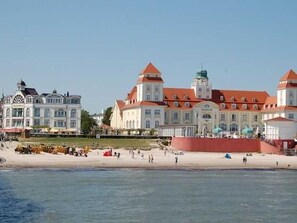 A waterfront hotel with a large building, a beach, and a red wall. - Apartment 1 - NEW! Rental Binz (Binz)