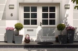 A white building with a double door, number 6, potted plants, and a small basket. - Apartment 1 - NEW! Rental Binz (Binz)