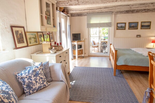 Un dormitorio acogedor con cama, sofá, televisor y ventana con vistas.
