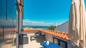 A rooftop terrace with outdoor seating, a view of the sea, and a tiled roof. - Beautiful home in Tkon (Tkon)