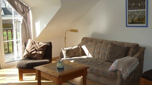 A cozy living room with a sofa, a chair, a table, and a lamp.