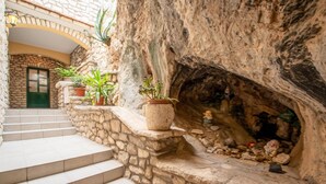 Una scala in pietra che conduce a una porta, con vasi di piante sui gradini.